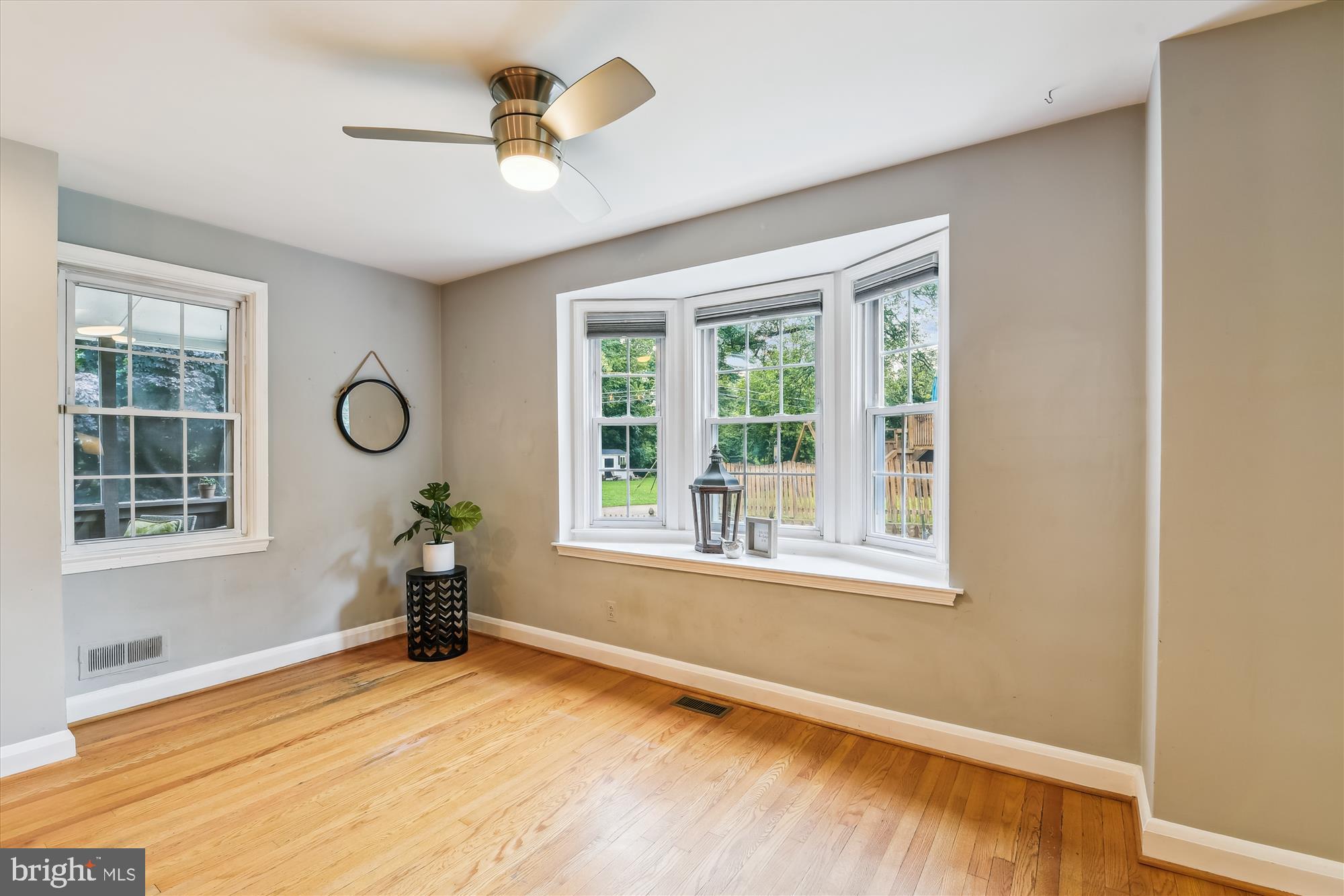 130 Stanmore Road Baltimore, MD 21212 - Photo 12 of 70 an empty room with wooden floor chandelier fan and windows