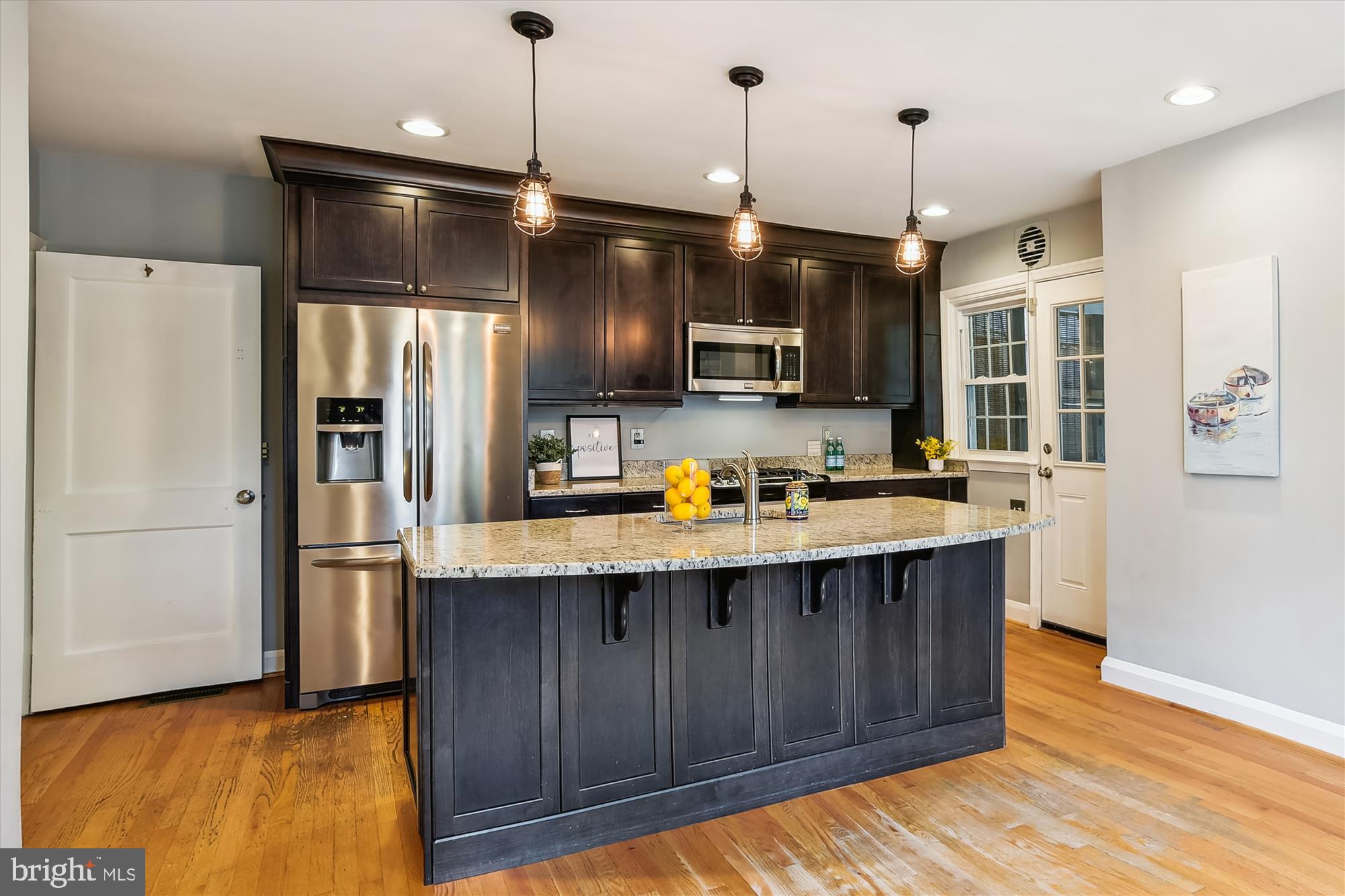 130 Stanmore Road Baltimore, MD 21212 - Photo 18 of 70 a kitchen with kitchen island a refrigerator a stove a sink and a oven with wooden floor