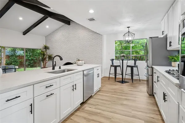 a large white kitchen with a large window