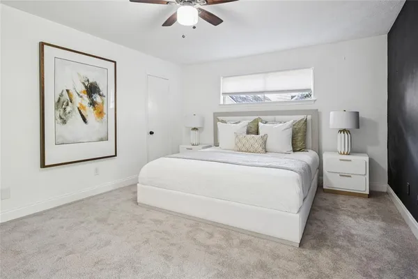 a bedroom with a large bed and a chandelier