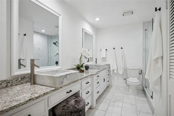a bathroom with a granite countertop sink a toilet and shower