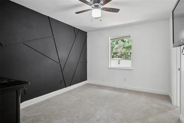 a view of a livingroom with a ceiling fan and window