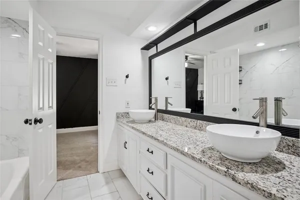 a spacious bathroom with a granite countertop sink and a mirror