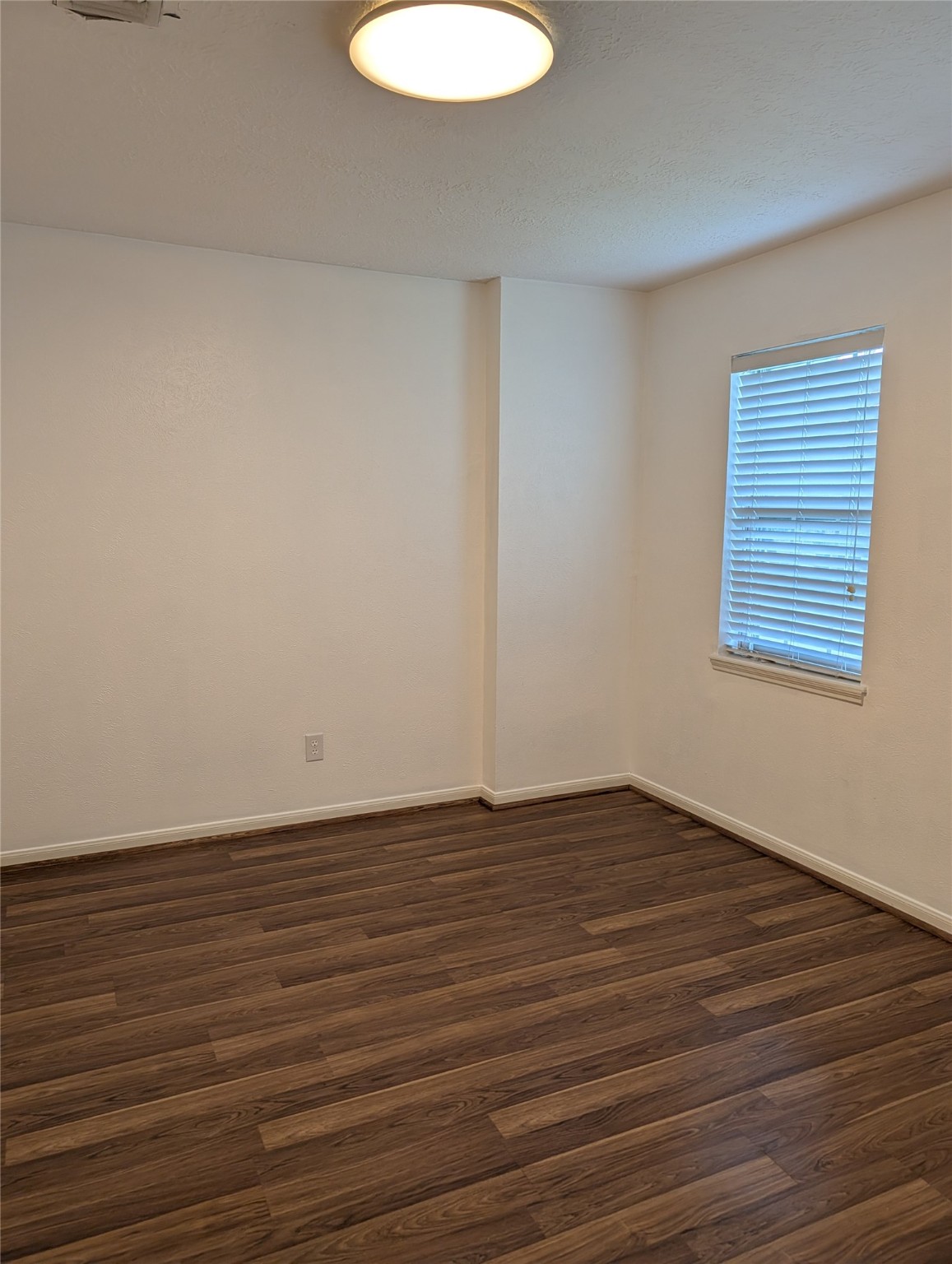 7810 12 Fairway Lane Humble, TX 77346 - Photo 16 of 18 a view of an empty room with wooden floor and a window