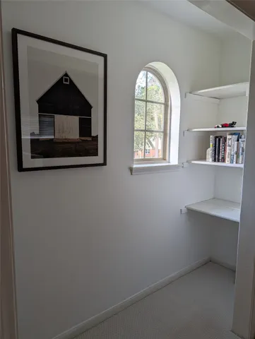 a living room with a cabinet and a window