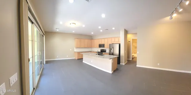 a view of kitchen with kitchen island and stainless steel appliances