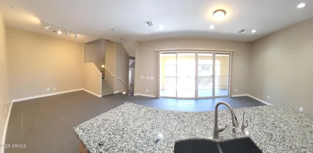 a kitchen with stainless steel appliances granite countertop a refrigerator a sink and white cabinets