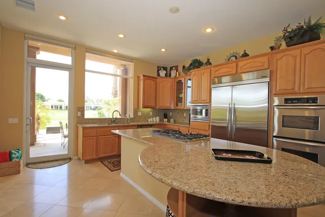 a kitchen with stainless steel appliances granite countertop a sink a stove and a refrigerator