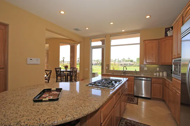 a kitchen with a stove a sink a refrigerator and blue cabinets with wooden floor