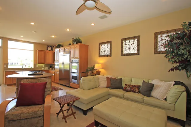 a living room with furniture kitchen view and a large window