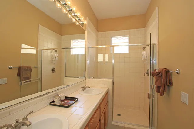 a bathroom with a double vanity sink toilet and shower