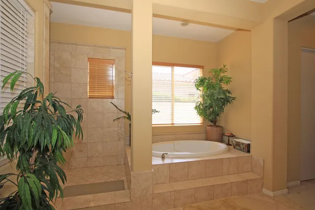 a spacious bathroom with a sink a large mirror and a shower