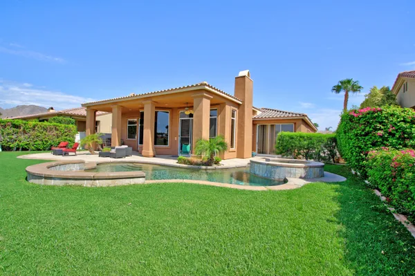 a view of a house with a yard patio and swimming pool