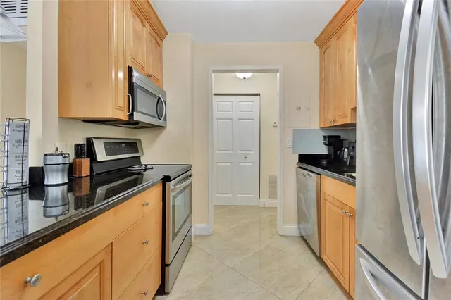 a kitchen with stainless steel appliances granite countertop a refrigerator and a stove top oven