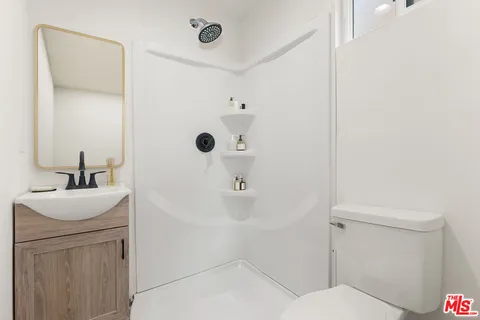 a bathroom with a sink a toilet and shower