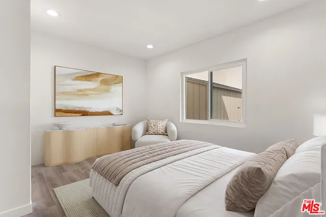 a bedroom with a bed and a painting on the wall