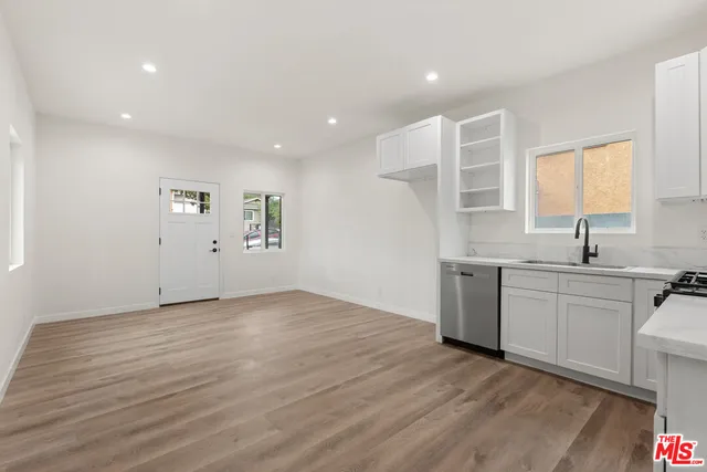a view of a kitchen with a sink a refrigerator and window