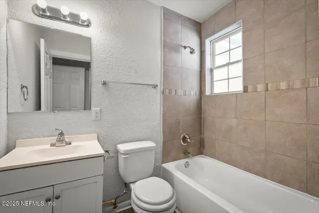 an empty room with a ceiling fan and a window