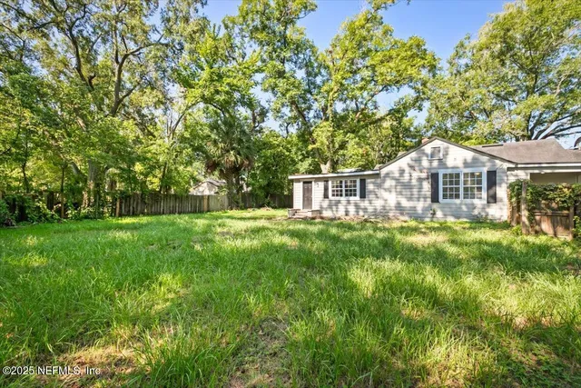 a front view of a house with yard and green space