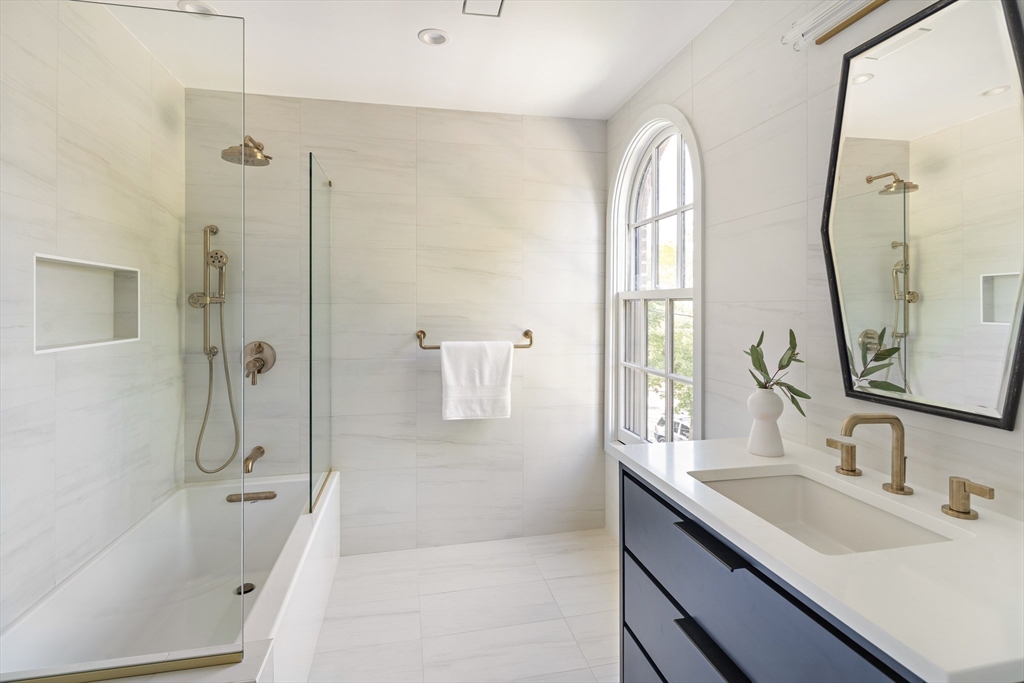 115 Mandalay Road Newton, MA 02459 - Photo 22 of 27 a bathroom with a double vanity sink mirror double vanity and bathtub
