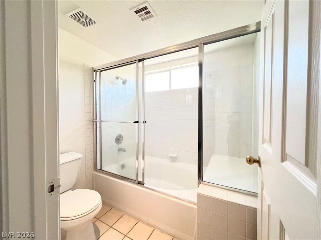 8284 West Rochelle Avenue Las Vegas, NV 89147 - Photo 26 of 29 A well-maintained bathroom with a combination tub and shower featuring glass sliding doors and ceramic tile flooring.