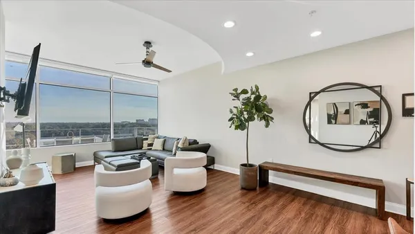 a living room with furniture a window and a potted plant