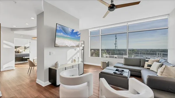 a living room with furniture a rug and a floor to ceiling window