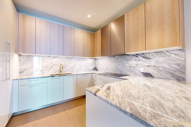 a kitchen with a sink cabinets and wooden floor