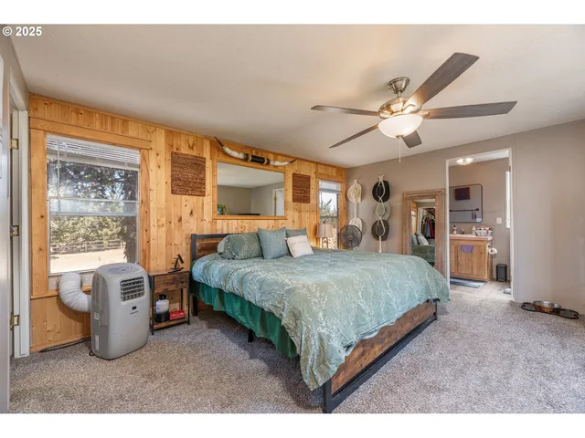 a spacious bedroom with a bed a table and a chandelier