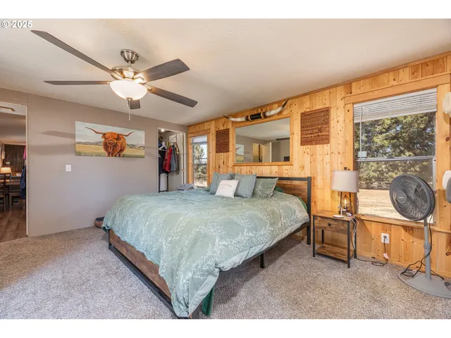 a bedroom with a bed a dresser and next to a window