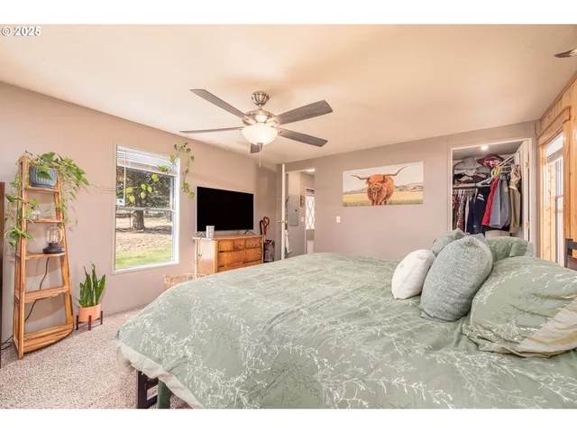 a bedroom with a large bed and a flat screen tv