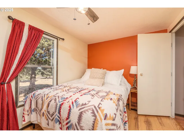 a bedroom with a bed and a large window