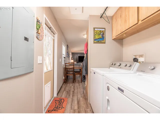 a utility room with dryer washer and a view of living area
