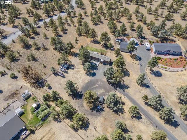 an aerial view of a house with a yard and a wooden fence