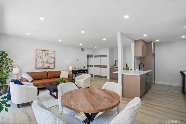 a living room with furniture and a dining table with wooden floor