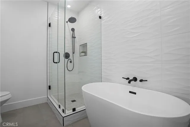 a bathroom with a bathtub a toilet and a shower