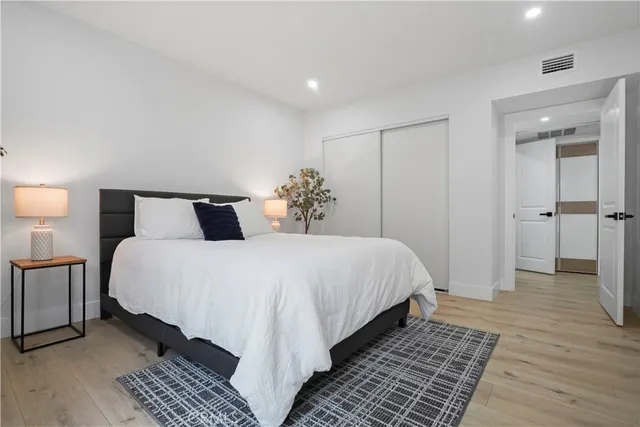 a bedroom with a bed and wooden floor