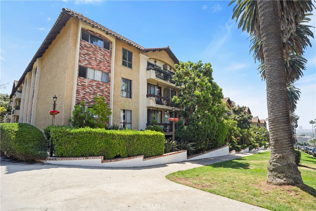 1730 Camino Palmero Street, Unit 316 Los Angeles, CA 90046 - Photo 25 of 27 a front view of a multi story residential apartment building with yard and green space