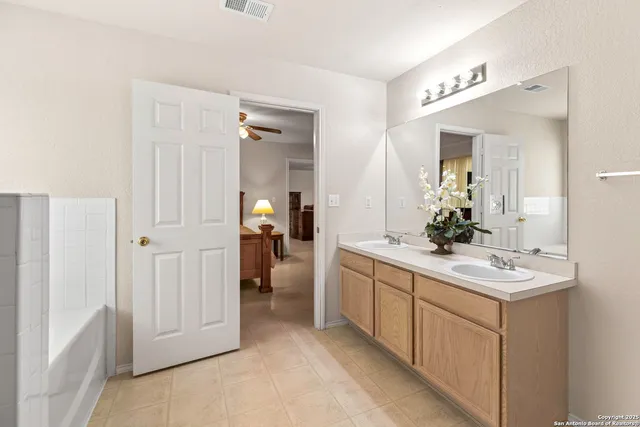 a spacious bathroom with a double vanity sink and mirror