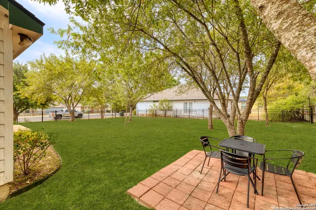 a view of a patio with table and chairs with wooden fence and plants