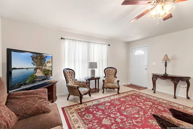a living room with furniture a rug and a flat screen tv