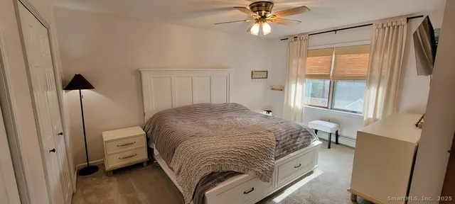 a spacious bedroom with a bed and a window