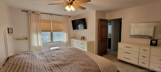 a bedroom with a bed and a flat tv screen on dresser