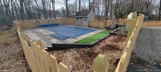 a view of a backyard with wooden fence