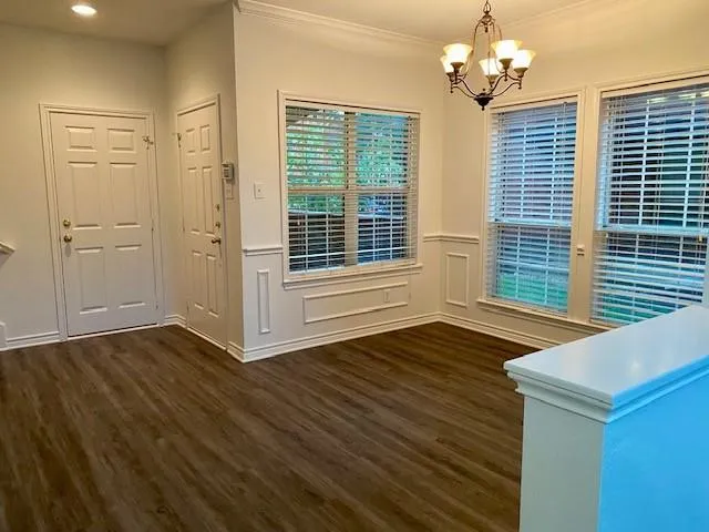 a view of wooden door and chandelier in a room