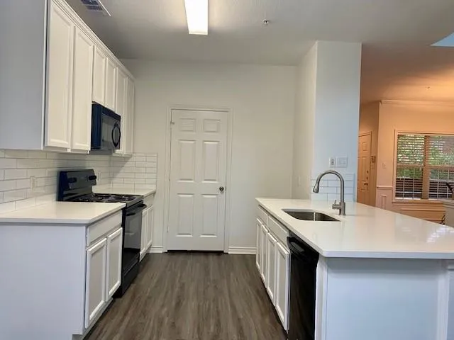 a kitchen with a sink stove top oven and cabinets