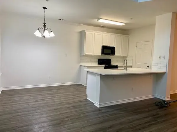 a kitchen with kitchen island granite countertop stainless steel appliances a stove top oven and cabinets