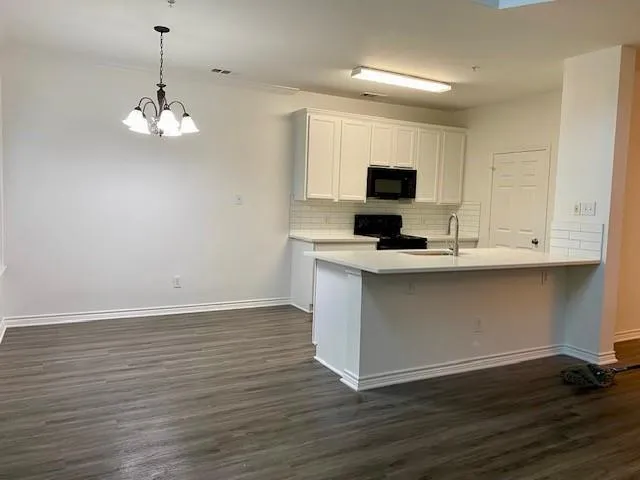 a kitchen with kitchen island granite countertop stainless steel appliances a stove top oven and cabinets