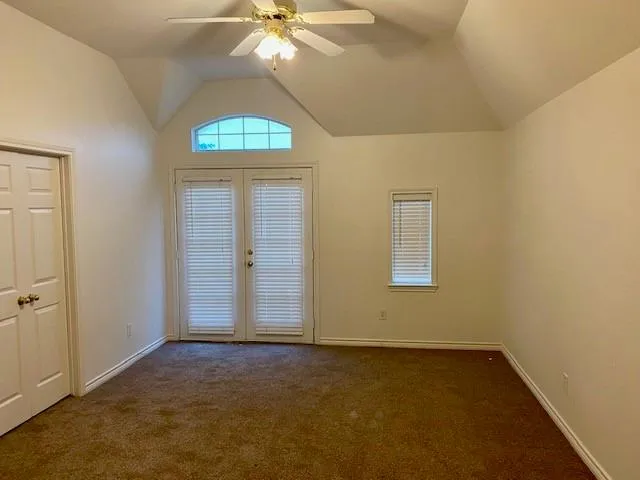 an empty room with a fan & a window