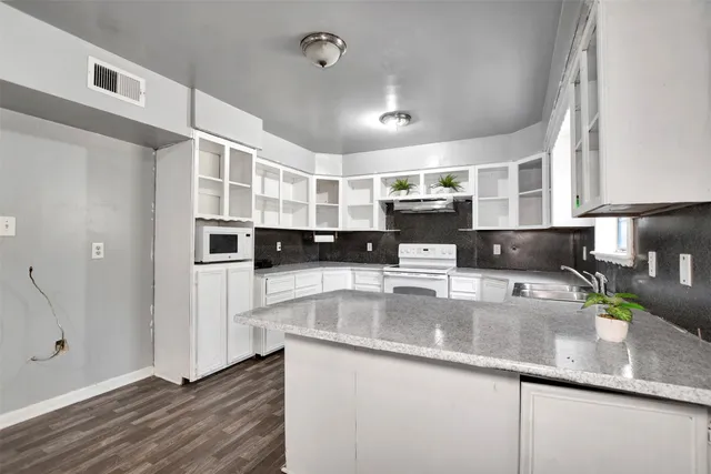 a large kitchen with stainless steel appliances granite countertop a lot of counter space and a sink